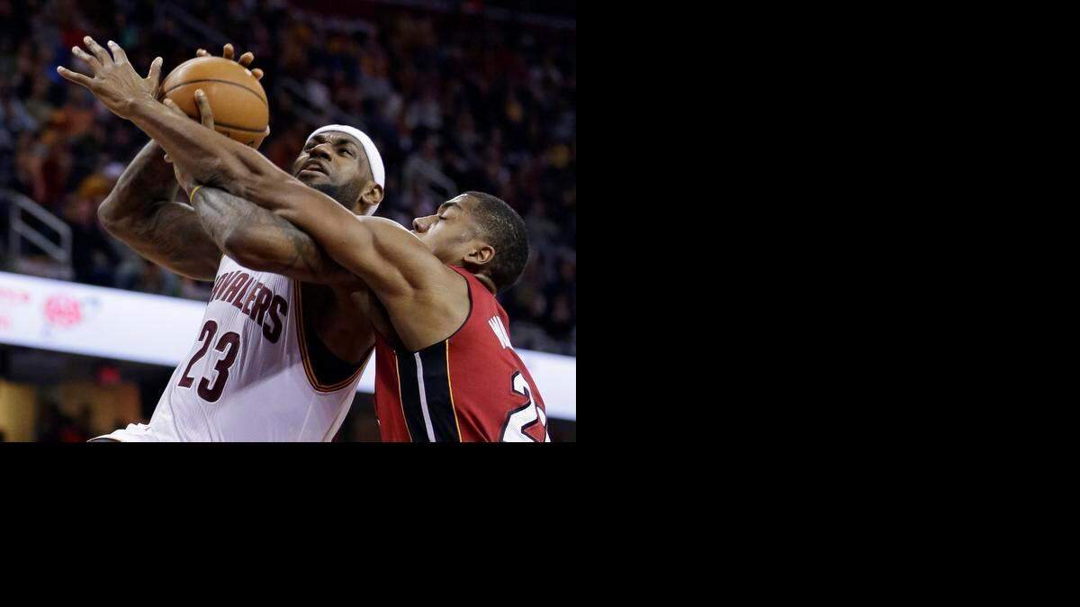 
El jugador del Heat Hassan Whiteside (der.) trata de evitar la canasta de la estrella de los Cavaliers LeBron James, en el partido efectuado el miércoles en Cleveland.


