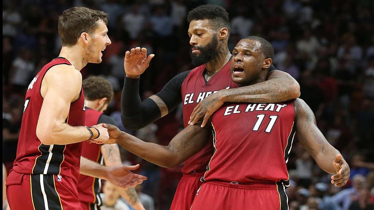 James Johnson y Goran Dragic (izq.) felicitan a Dion Waiters (11) tras una canasta del Heat, el miércoles.
