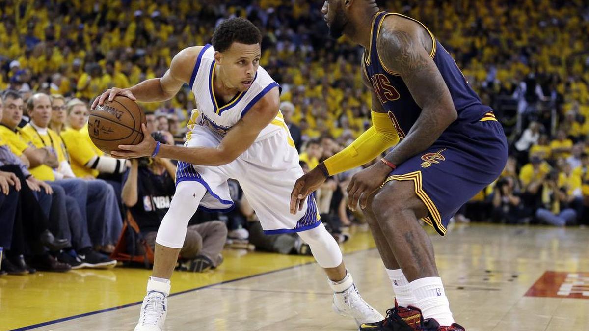 LeBron James, de los Cavaliers, marca a la estrella de los Warriors Stephen Curry (izq.) el 14 de junio del 2015.