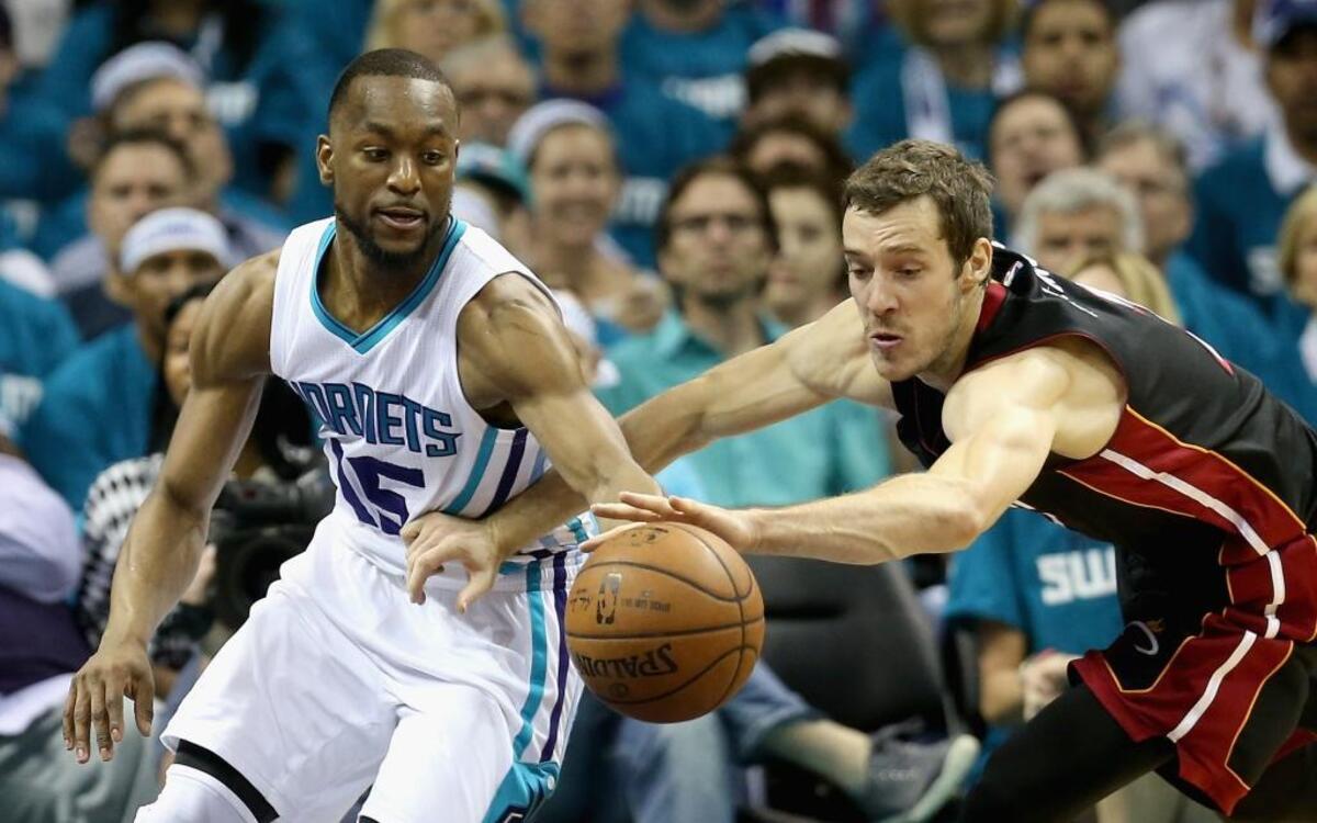 Kemba Walker, de los Hornets (izq.), pelea por el balón con el armador del Heat Goran Dragic, el lunes 25 de abril del 2016 en Charlotte.