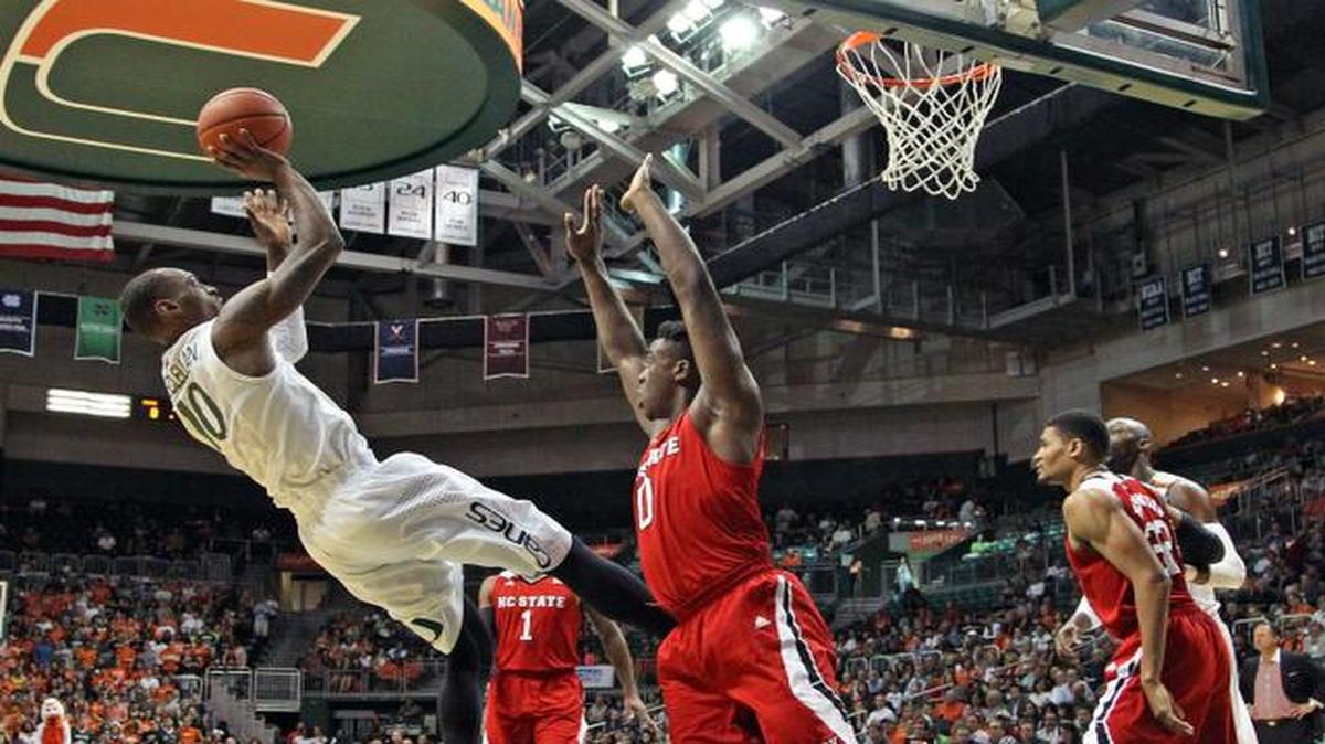 
El jugador de los Huracanes Sheldon McClellan (izq.) lanza al aro en la primera mitad del partido contra North Carolina State, el jueves en Miami.


