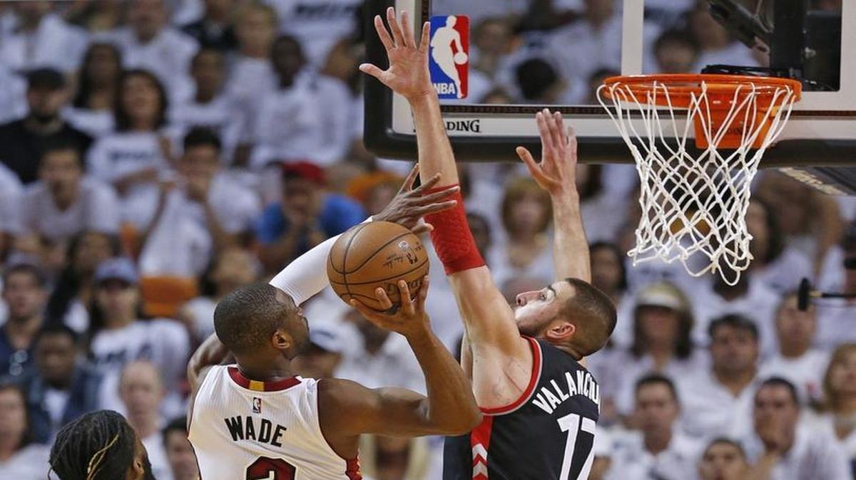 Dwyane Wade (3) tira al aro ante la marca del centro de los Raptors Jonas Valanciunas (17), en el tercer partido del playoff semifinal de la Conferencia Este, celebrado el 7 de mayo en Miami.