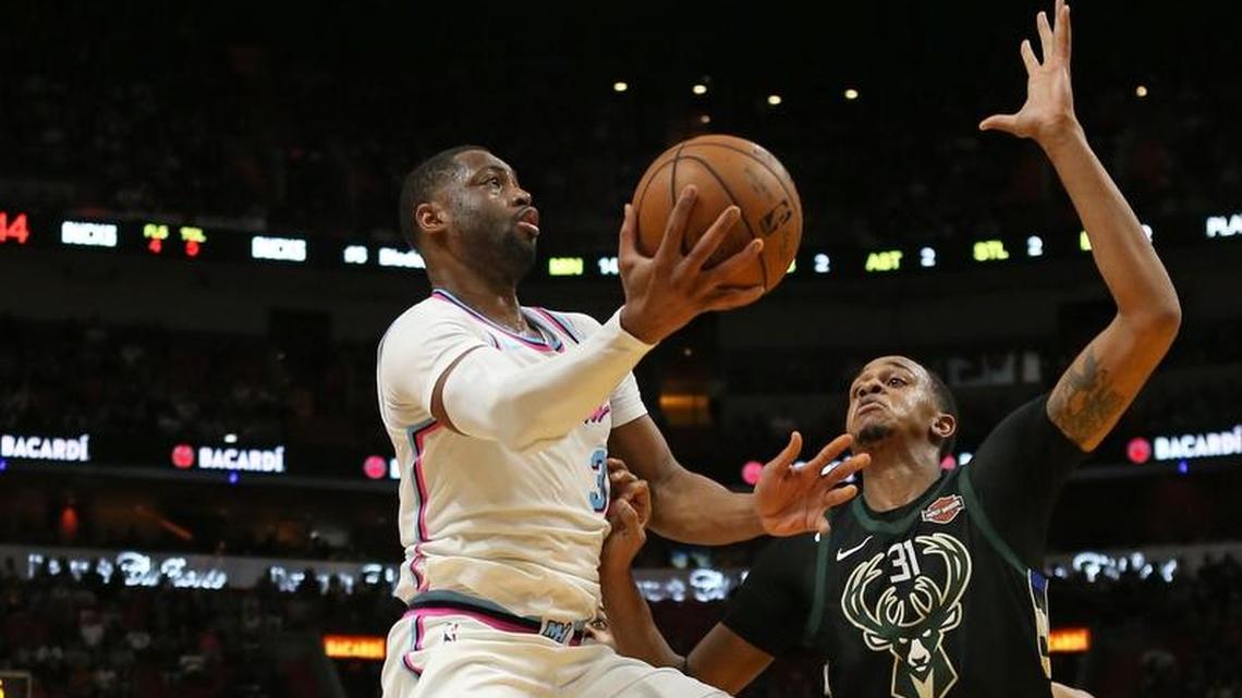 El escolta del Heat Dwyane Wade entra al aro ante la marca del centro de los Bucks John Henson este viernes en el American Airlines Arena.
