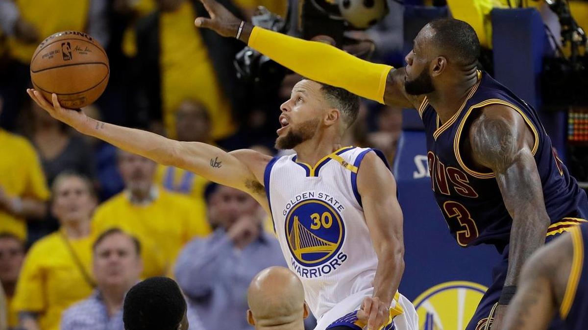 Stephen Curry (30), de los Warriors, se dispone a lanzar marcado por LeBron James, de los Cavs, el jueves.