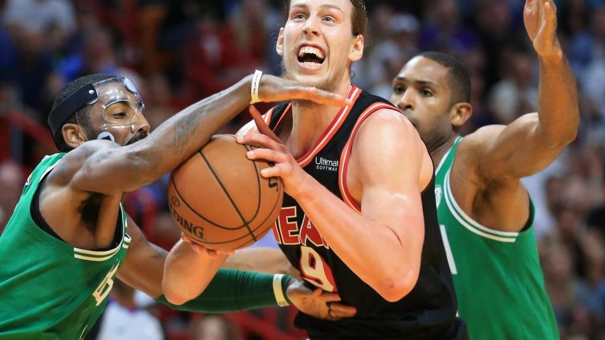 El centro del Heat Kelly Olynyk (9) intenta tirar al aro ante la marca de Kyrie Irving (11) y Al Horford, de los Celtics el 22 de noviembre en el American Airlines Arena.
