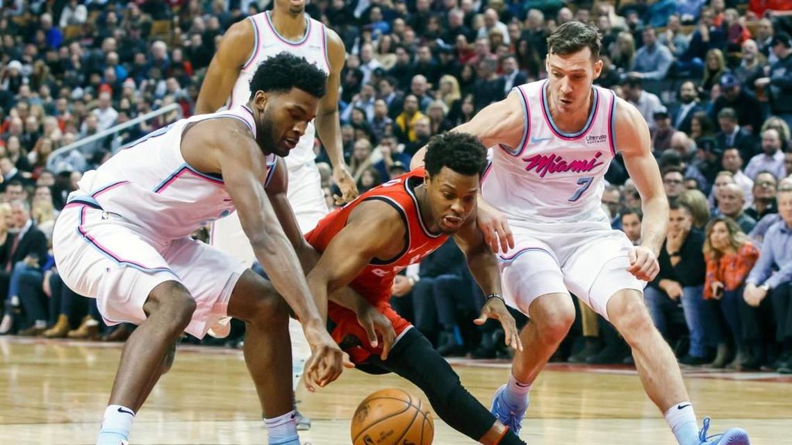 El jugador de los Raptors Kyle Lowry (centro) lucha por la pelota con Goran Dragic (der.) y Justise Winslow, del Heat, en el partido efectuado el 13 de febrero de 2018 en Toronto.