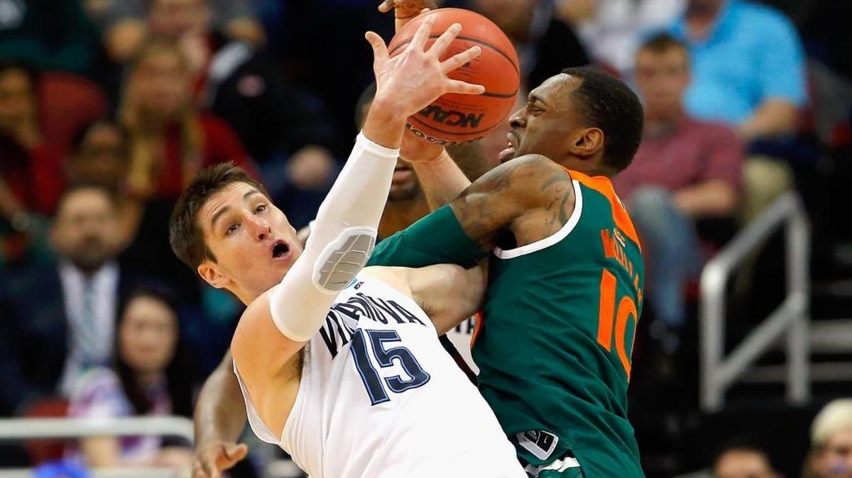 Ryan Arcidiacono (15), de los Wildcats de Villanova, y Sheldon McClellan (10), de la UM, luchan el jueves.