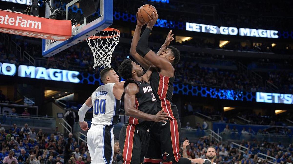Hassan Whiteside (21), del Heat, gana el rebote al lado de Justise Winslow, y Aaron Gordon (00), del Magic.
