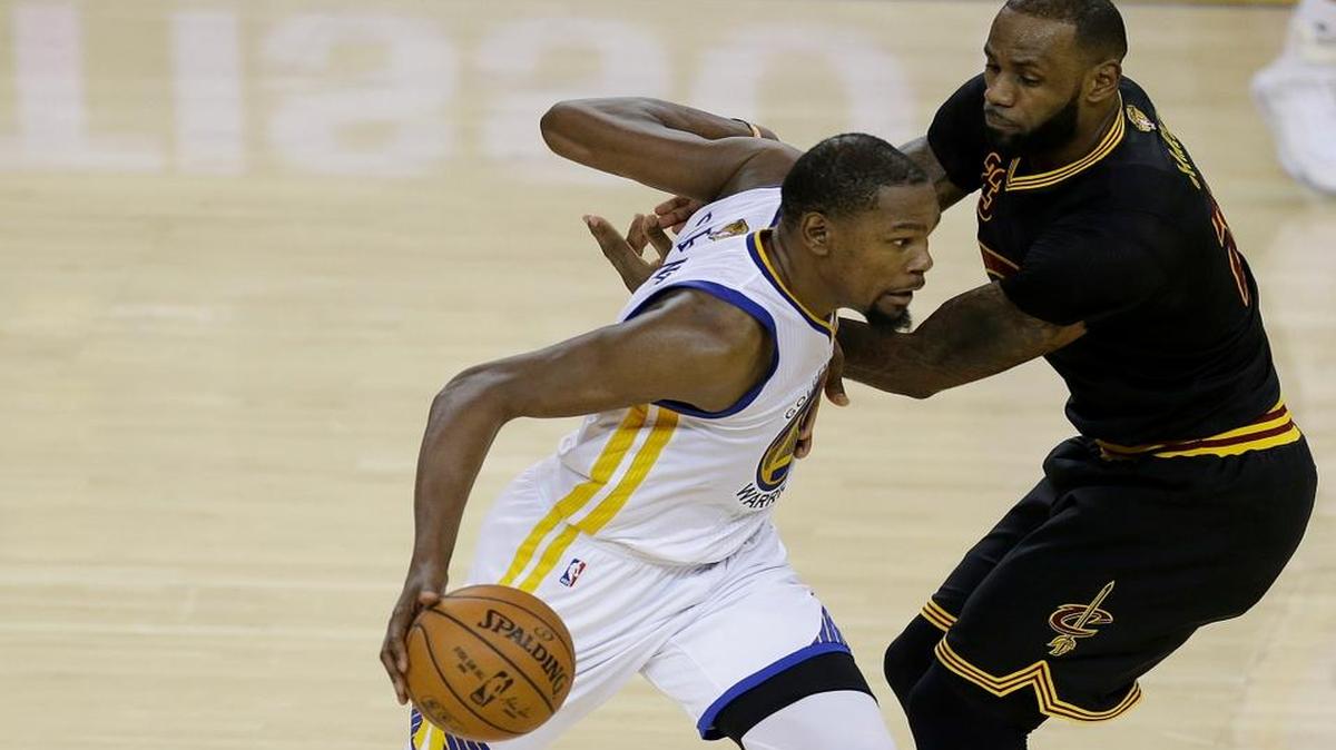 LeBron James, de los Cavaliers, trata de detener a Kevin Durant, de los Warriors (izq.), en el Juego 2 de las Finales de la NBA, el domingo en el Oracle Arena de Oakland.