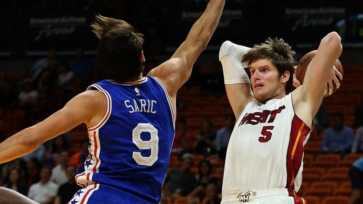Luke Babbitt, del Heat, busca pasar la bola sobre Dario Saric, de los Sixers, en el AmericanAirlines Arena en Miami el viernes 21 de octubre del 2016.