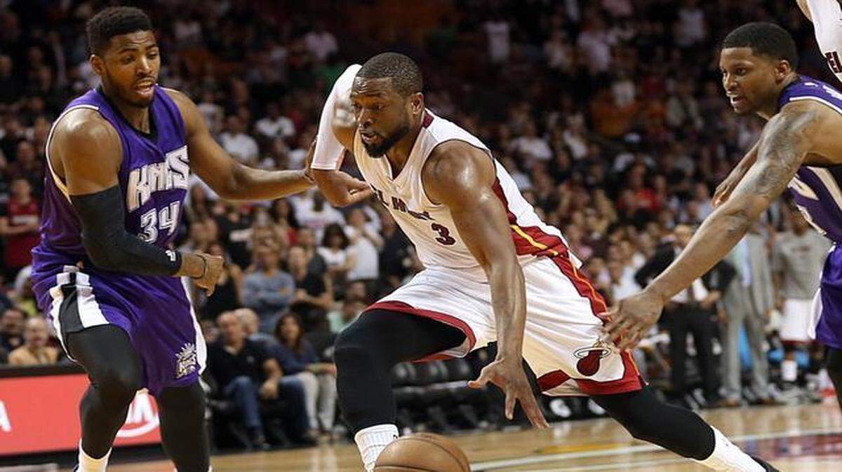 
Dwyane Wade (centro) avanza hacia al aro ante dos jugadores de los Kings, el sábado en Miami.


