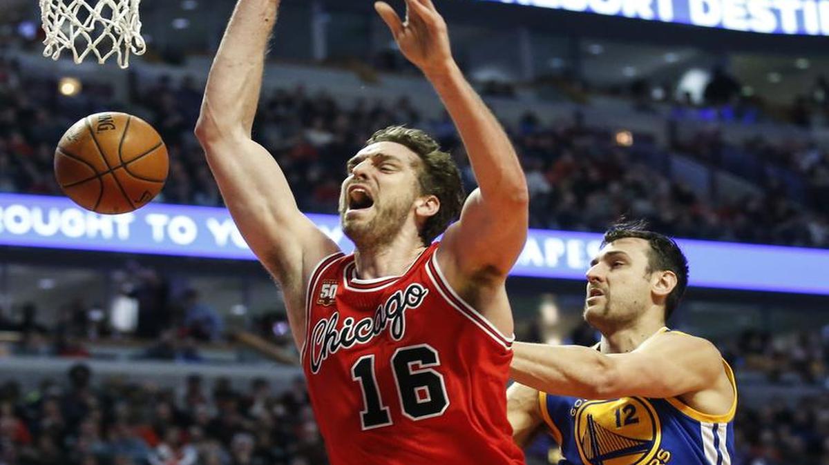 El jugador de los Bulls Pau Gasol (izq.) recibe una falta de Andrew Bogut, de los Warriors, en el partido efectuado el miércoles 20 de enero de 2016.