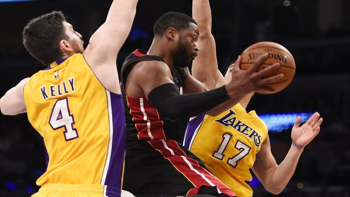 
El escolta del Heat Dwyane Wade (centro) trata de superar la marca de Ryan Kelly (izq.) y Jeremy Lin, de los Lakers, en el partido donde Miami se impuso el martes 78-75 en Los Angeles.
