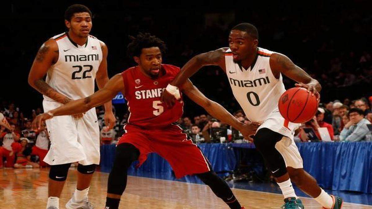 
Ja'Quan Newton (#0) trata de entrar al aro ante la marca de Chasson Randle (#5), en el partido entre Miami y Stanford, el jueves en Nueva York
