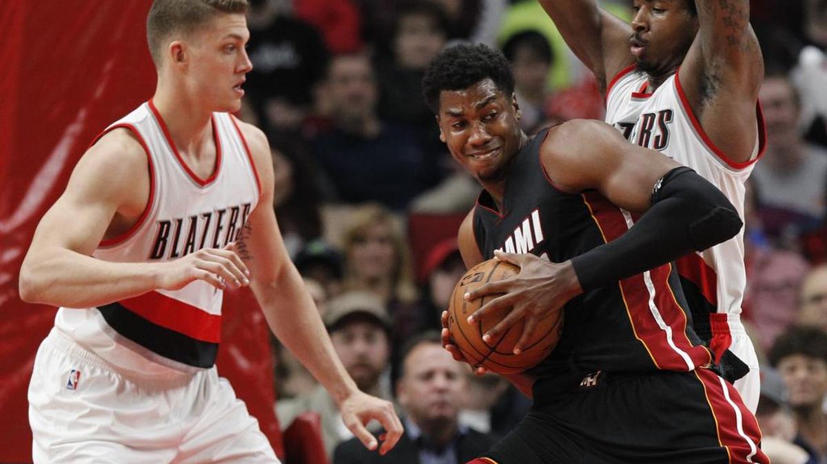 El centro del Heat Hassan Whiteside (centro) trata de anotar entre los jugadores de los Trail Blazers Meyers Leonard (izq.) y Ed Davis, en Portland