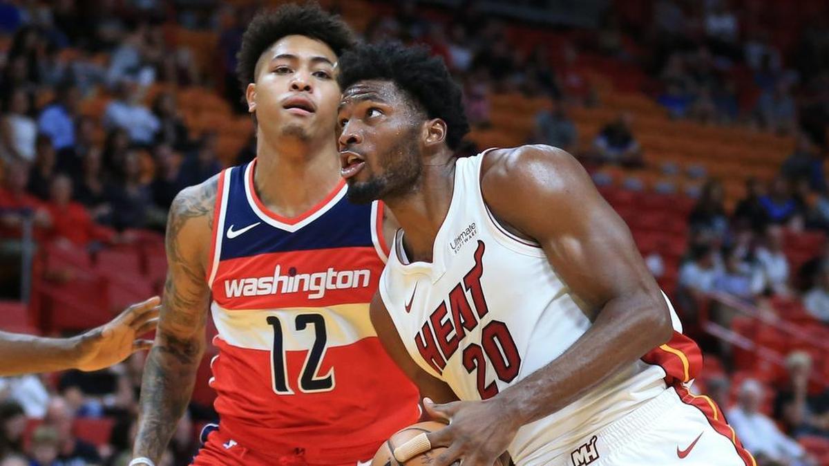 El jugador del Heat Justise Winslow (der.) entra al aro ante la marca de Kelly Oubre Jr., de los Wizards, en el primer cuarto del partido efectuado el 11 de octubre del 2017 en Miami.