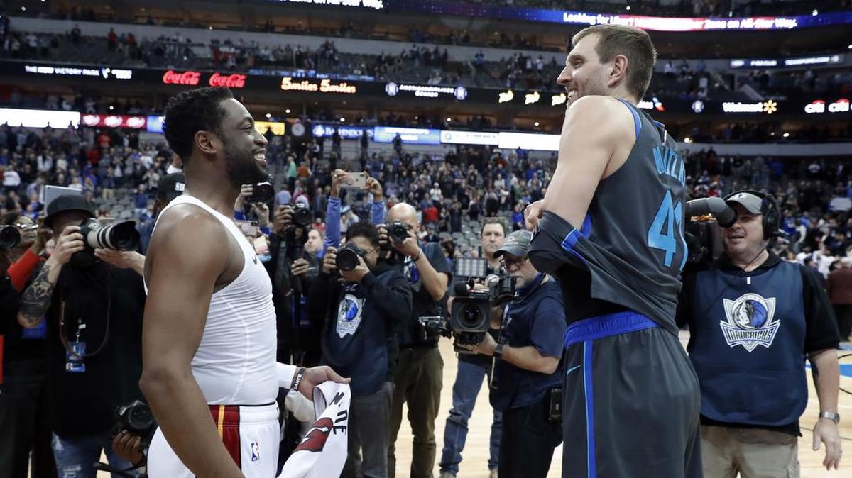 Dwyane Wade (izq.) y Dirk Nowitzki intercambian camisetas luego del partido entre el Heat y los Mavericks, el 13 de febrero de 2019 en Dallas.