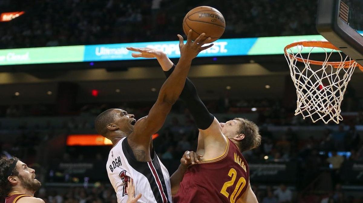 Chris Bosh (centro) busca la canasta por el Heat en el juego ante los Cavaliers, el sábado.
