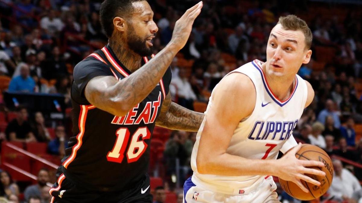 El delantero del Heat James Johnson (16) gardea a Sam Dekker, de los Clippers, antes de salir lesionado en el primer cuarto en el juego del sábado en el American Airlines Arena.