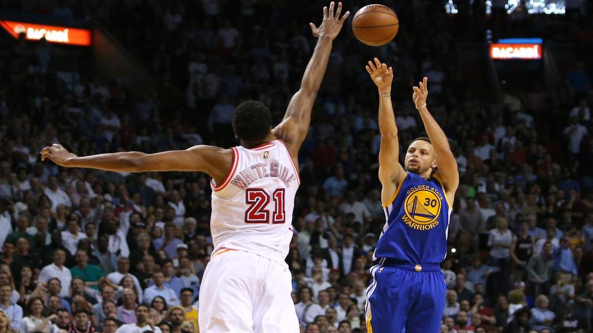 Stephen Curry tira al aro por los Warriors de Golden State ante la marca del centro del Heat Hassan Whiteside, durante el último cuarto del partido celebrado el miércoles en Miami.