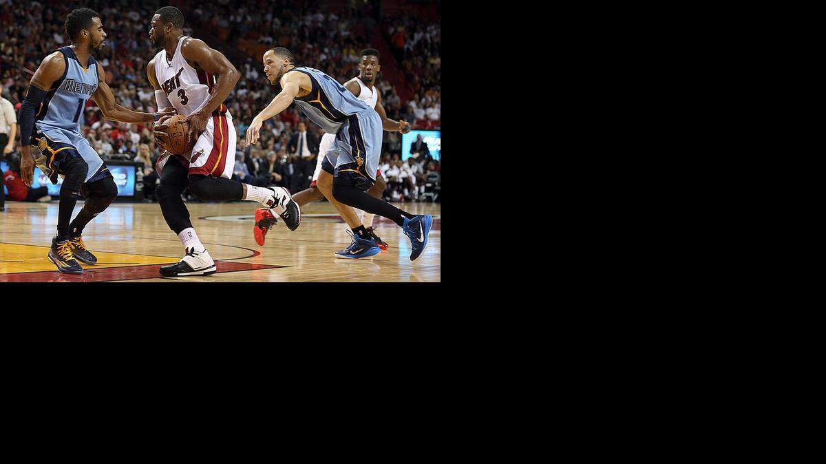 
El astro del Heat Dwyane Wade penetra al aro entre Mike Conley (izq.) y Tayshaun Prince #21, en el partido contra los Gizzlies del sábado en Miami.


