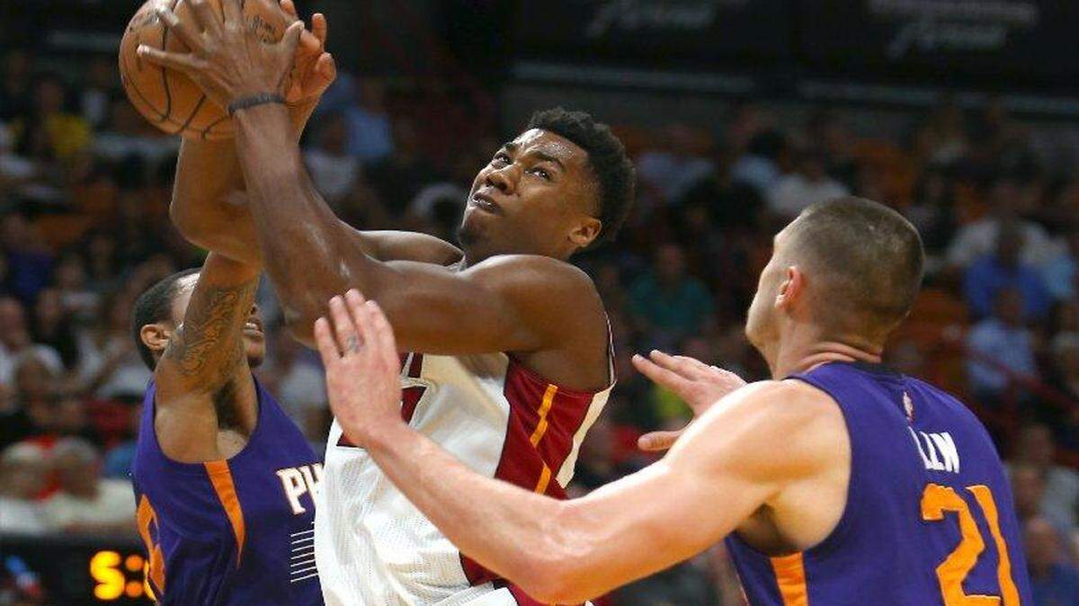 El centro de Miami Hassan Whiteside tira al aro ante la marca de Alex Len (21) y Tyler Ulis (8), del Suns, en el segundo cuarto del partido efectuado el 21 de marzo de 2017 en Miami.