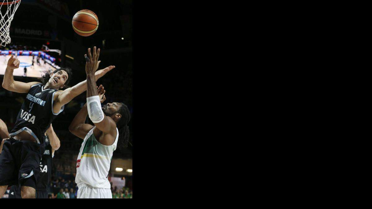 
El argentino Luis Scola (i) salta a por un balón con Nené Hilario, de Brasil.


