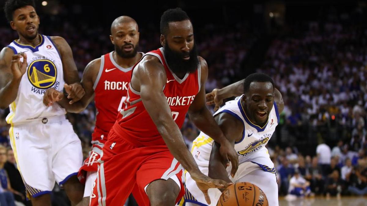 Draymond Green (der.) trata de robarle la pelota a James Harden en el partido entre los Warriors y los Rockets, el 17 de octubre del 2017.