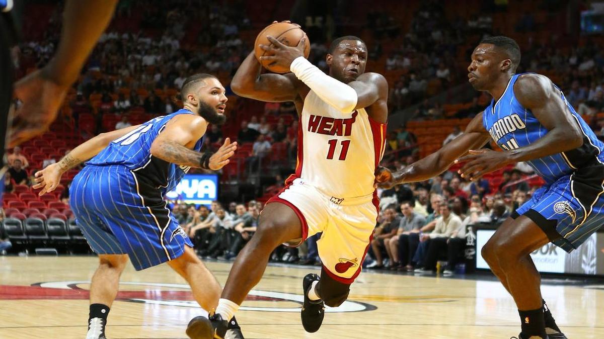 El jugador del Heat Dion Waiters entra al aro ante la marca de Evan Fournier (izq.) y Jeff Green, del Magic de Orlando, en el partido de pretemporada efectuado el 18 de octubre del 2016 en Miami.
