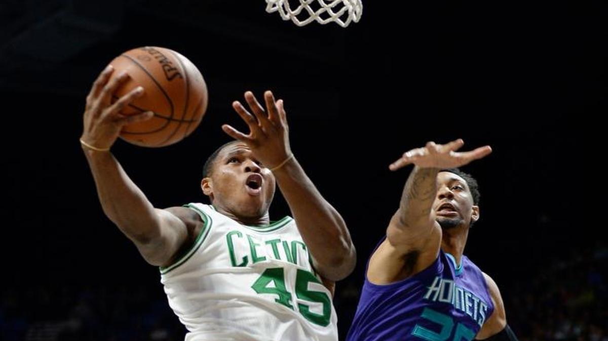 Marcus Georges-Hunt, con la camiseta de los Celtics (izq.), entra al aro marcado por el jugador de los Hornets Christian Wood, en un partido de prtemporada el 8 de octubre en Uncasville, Conn.