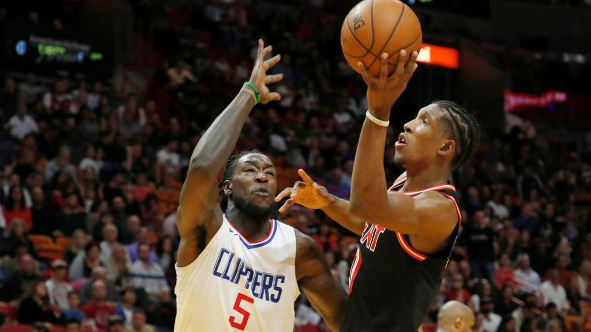 Josh Richardson (0), quien fuel mejor del Heat con 28 puntos, tira al aro ante la marca de Montrezl Harrell, de los Clippers (5), este sabado 16 de diciembre en el American Airlines Arena.
