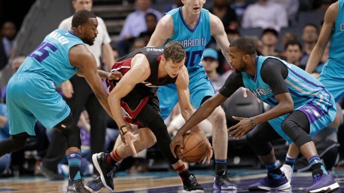 Goran Dragic, del Heat, es acorralado por Kemba Walker (izq.), Michael Kidd-Gilchrist (der.) y Cody Zeller (atrás), de los Hornets, en la primera mitad del partido en Charlotte, Carolina del Norte, la noche del miércoles 5 de abril del 2017.