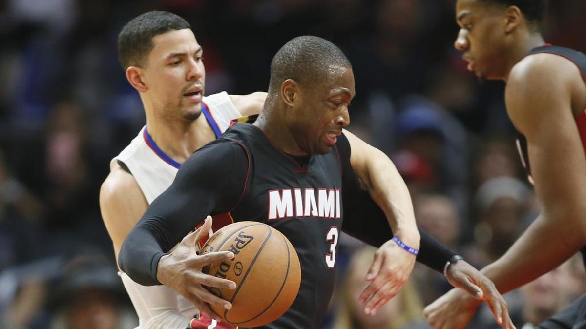 DWYANE WADE, del Heat, conduce la pelota en medio de la marca de Austin Rivers, de los Clippers (izq), el 13 de enero del 2016 en Los Angeles.