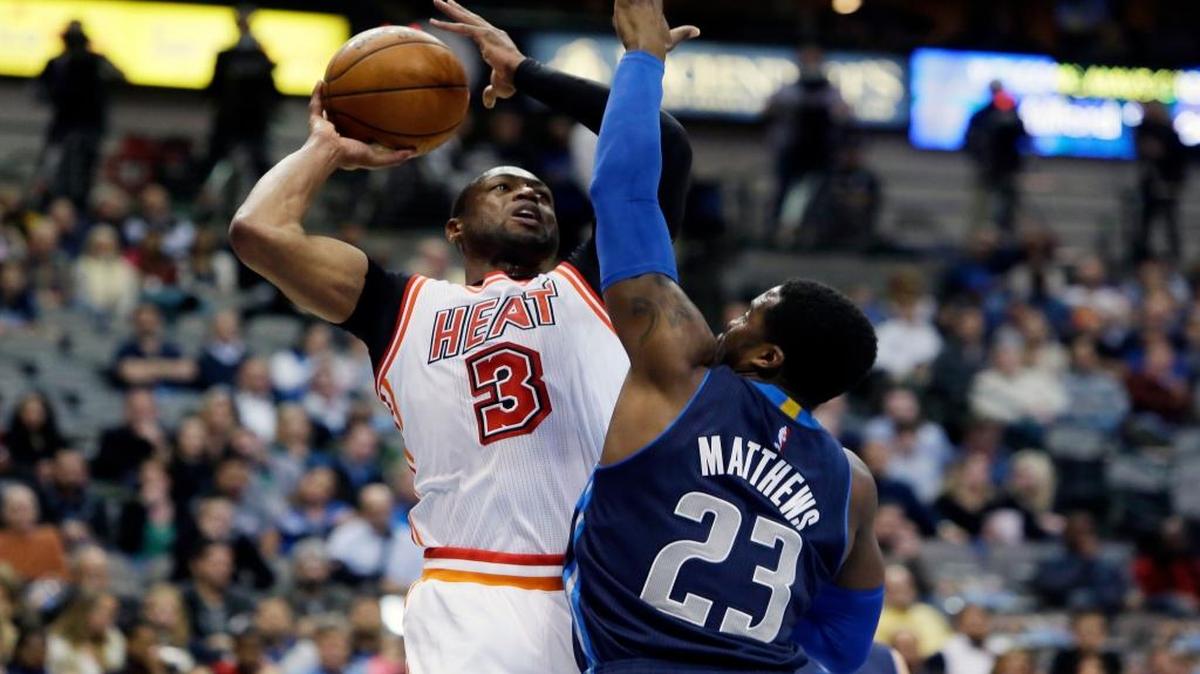 El astro del Heat Dwyane Wade (#3) tira al aro sobre Wesley Matthews (#23), de los Mavericks, el 3 de febrero del 2016 en Dallas.