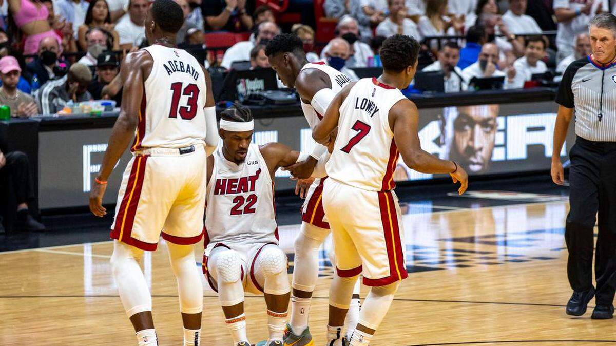 El alero del Miami Heat, Jimmy Butler (22), recibe ayuda de sus compañeros de equipo después de recibir una falta durante el segundo cuarto del Juego 7 de la serie de Finales de la Conferencia Este de la NBA contra los Boston Celtics en el FTX Arena de Miami, Florida, el domingo 29 de mayo de 2022.