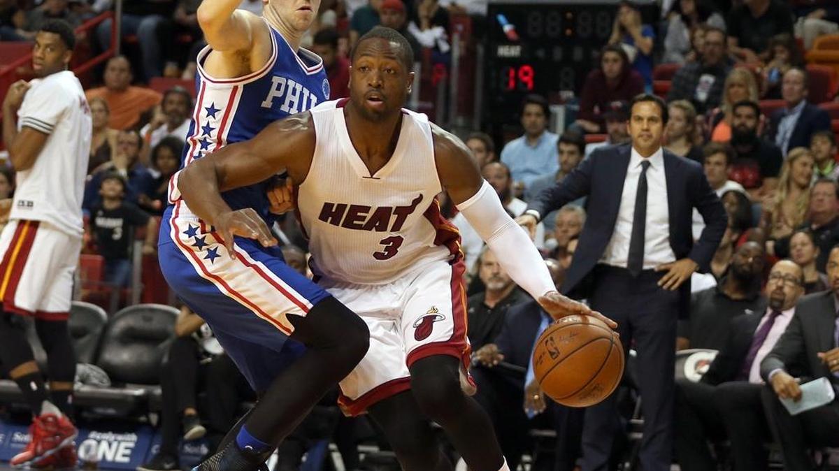 Dwyane Wade, del Heat, escapa a Nik Stauskas, de los Sixers, la noche del sábado en el AAA en Miami.