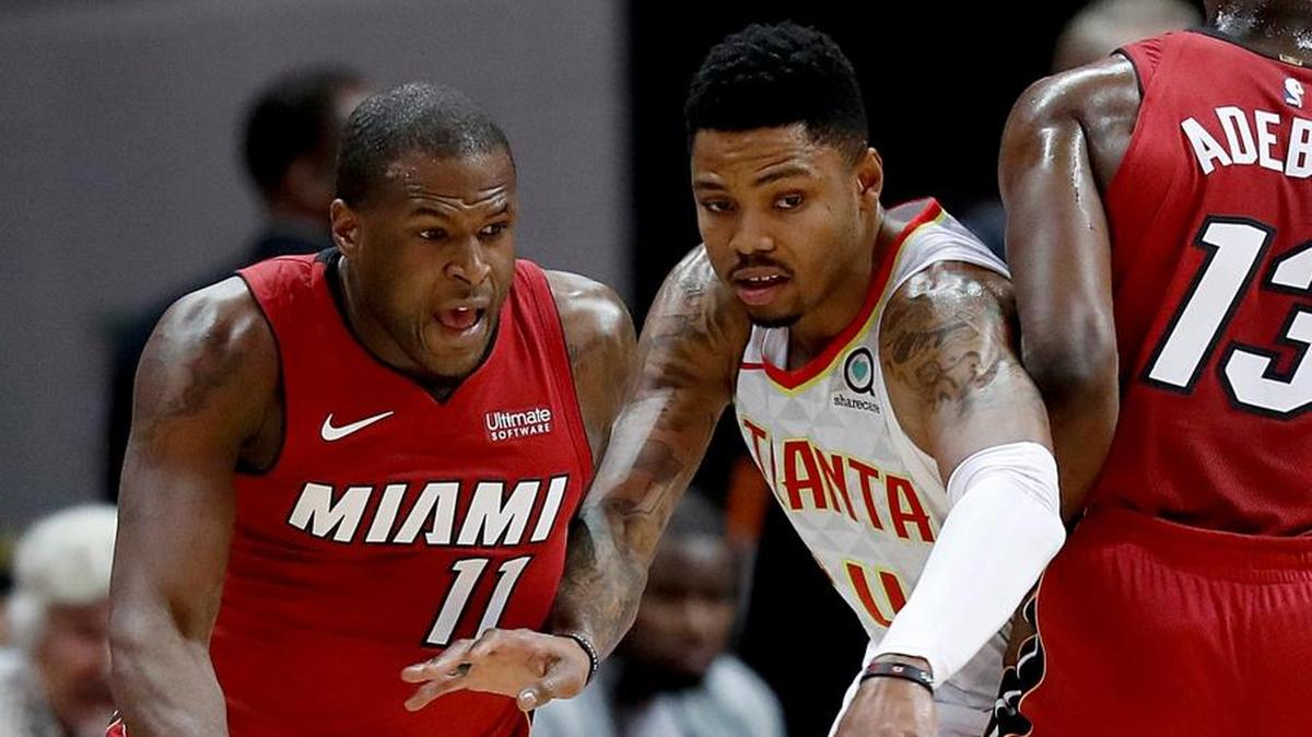 El centro del Heat Bam Adebayo (13) bloquea al jugador de los Hawks Kent Bazemore para que pase Dion Waiters (11) con el balón rumbo al aro este lunes en Atlanta.