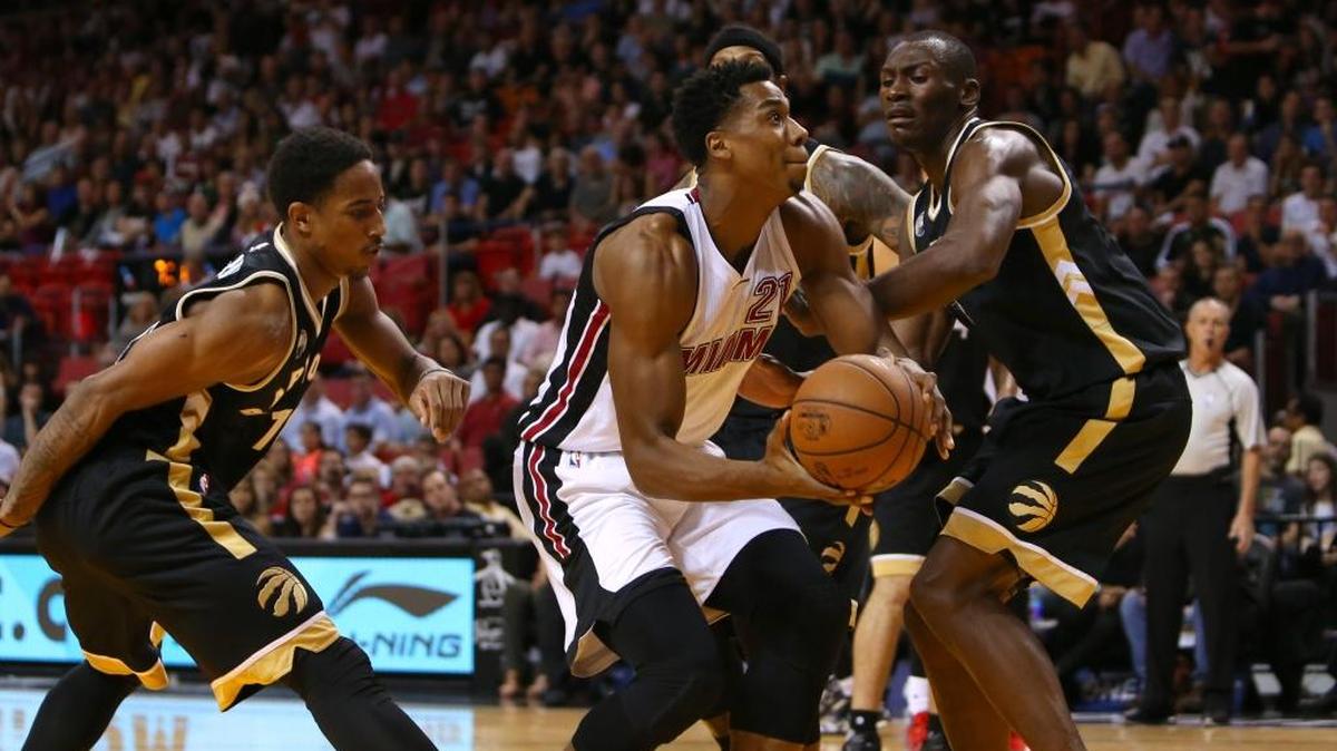 Hassan Whiteside, del Heat, se apresta a lanzar rodeado por DeMar DeRozan (izq.), James Johnson y Bismack Biyombo (der.), de los Raptors, en el AmericanAirlines Arena en Miami, la noche del viernes 18 de noviembre del 2015.