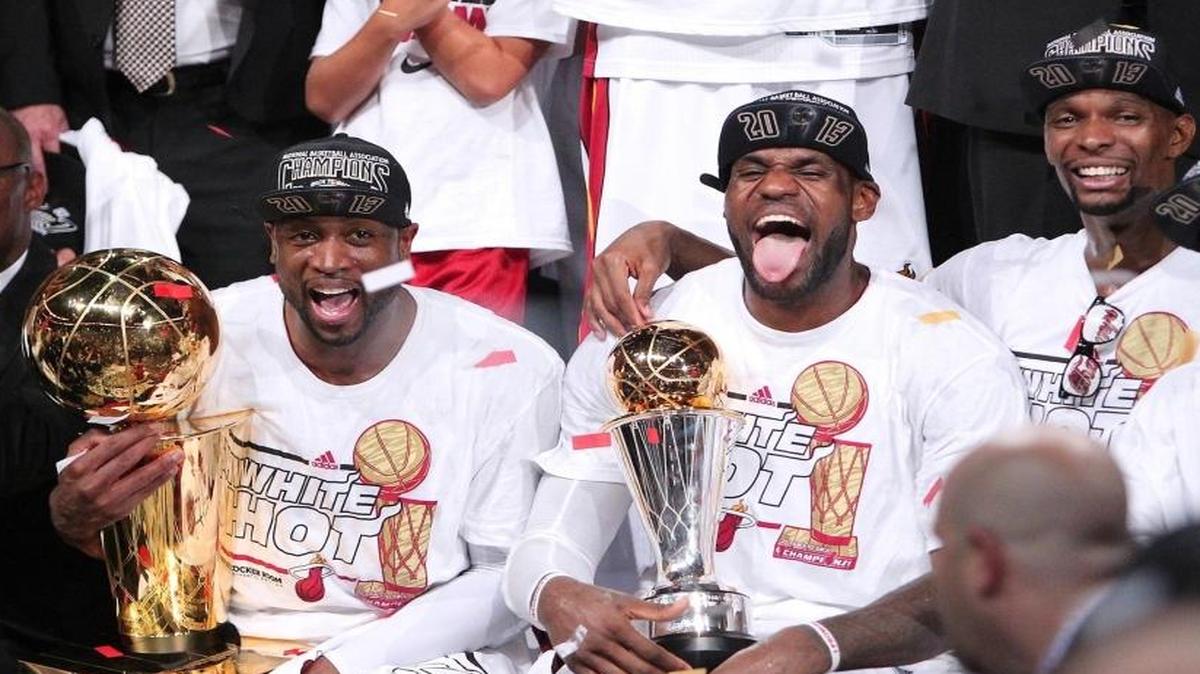 LeBron James (c) celebra junto a Dwyane Wade (izq.) y Chris Bosh (der.) el campeonato de la NBA el 20 de junio del 2013.