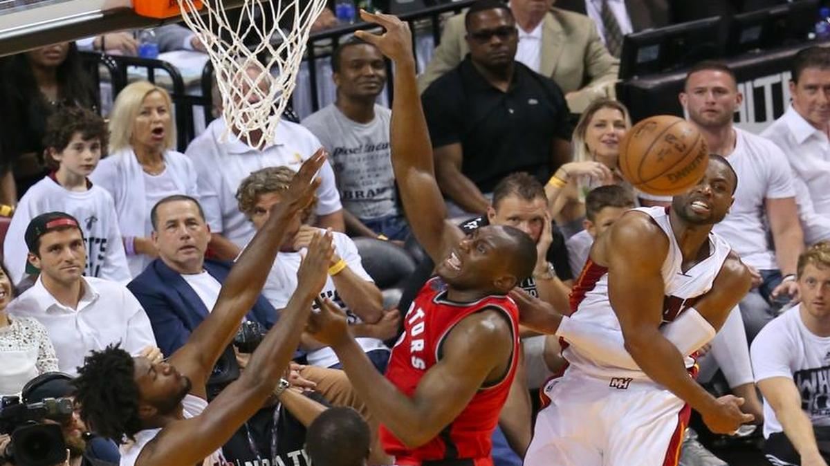 Dwyane Wade, del Heat, bloquea a Bismack Biyombo, de los Raptors, el viernes en Miami.