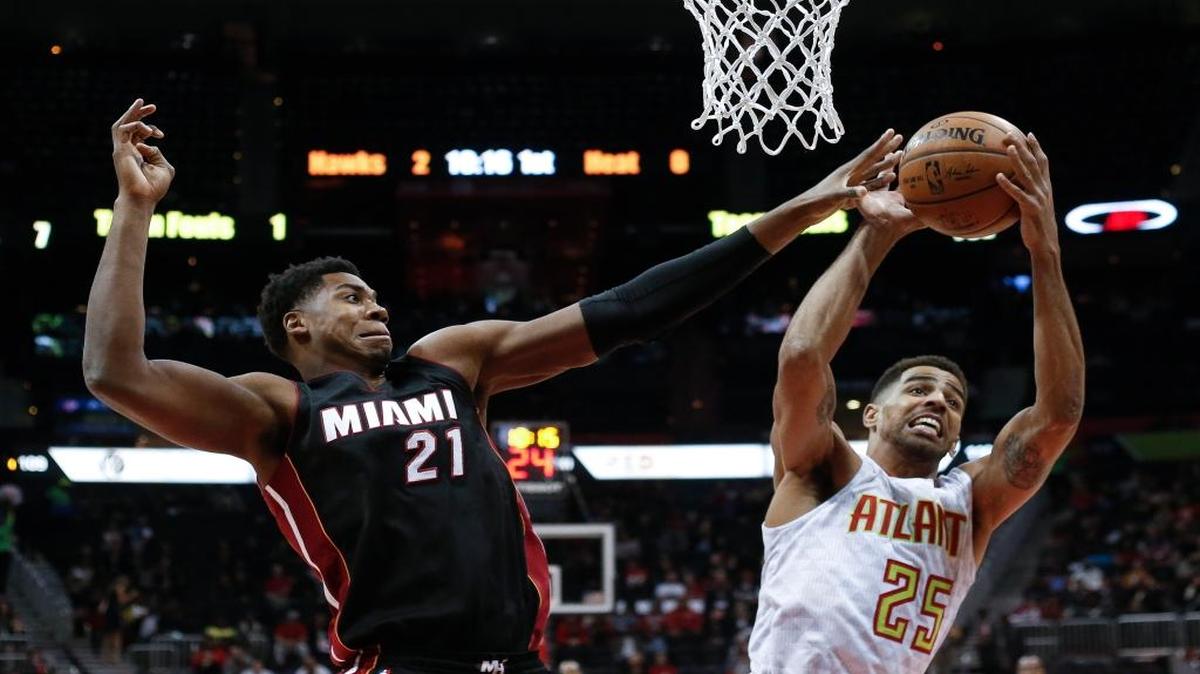 El centro de Miami Hassan Whiteside (izq.) trata de frenar a Thabo Sefolosha, del Hawks, el miércoles.