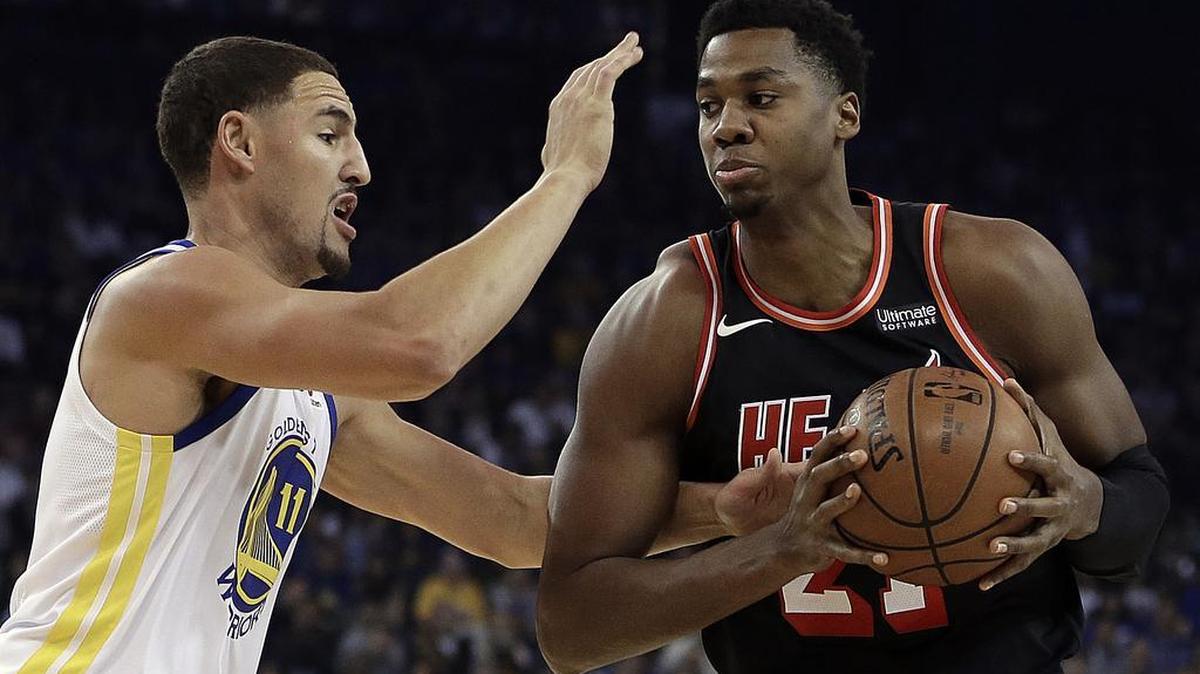 Hassan Whiteside, centro del Heat, trata de anotar ante la marca de Klay Thompson, de los Warriors (izq.), el lunes en Oakland.