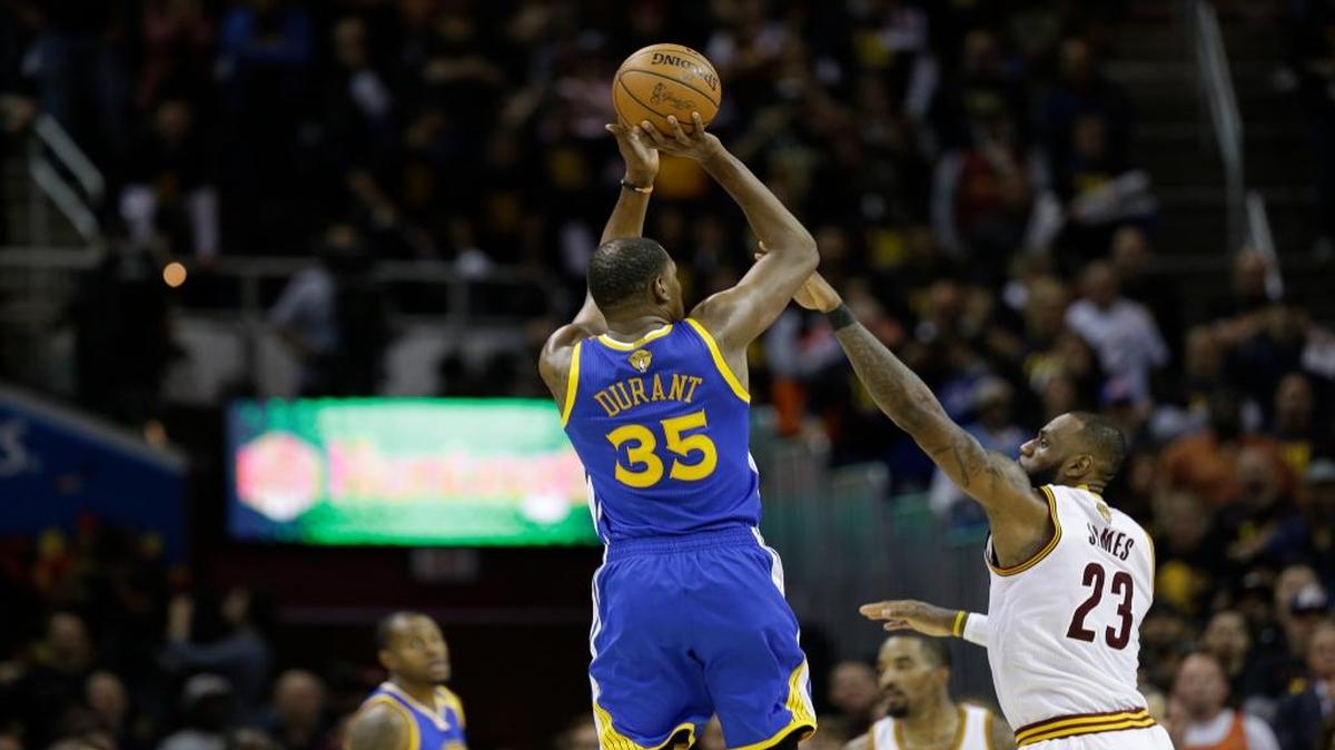 Kevin Durant, de los Warriors (35), lanza el triple que volteó el marcador en el último minuto ante la marca de LeBron James, de los Cavaliers, en el tercer partido de la Final de la NBA celebrado el 8 de junio del 2017 en Cleveland.