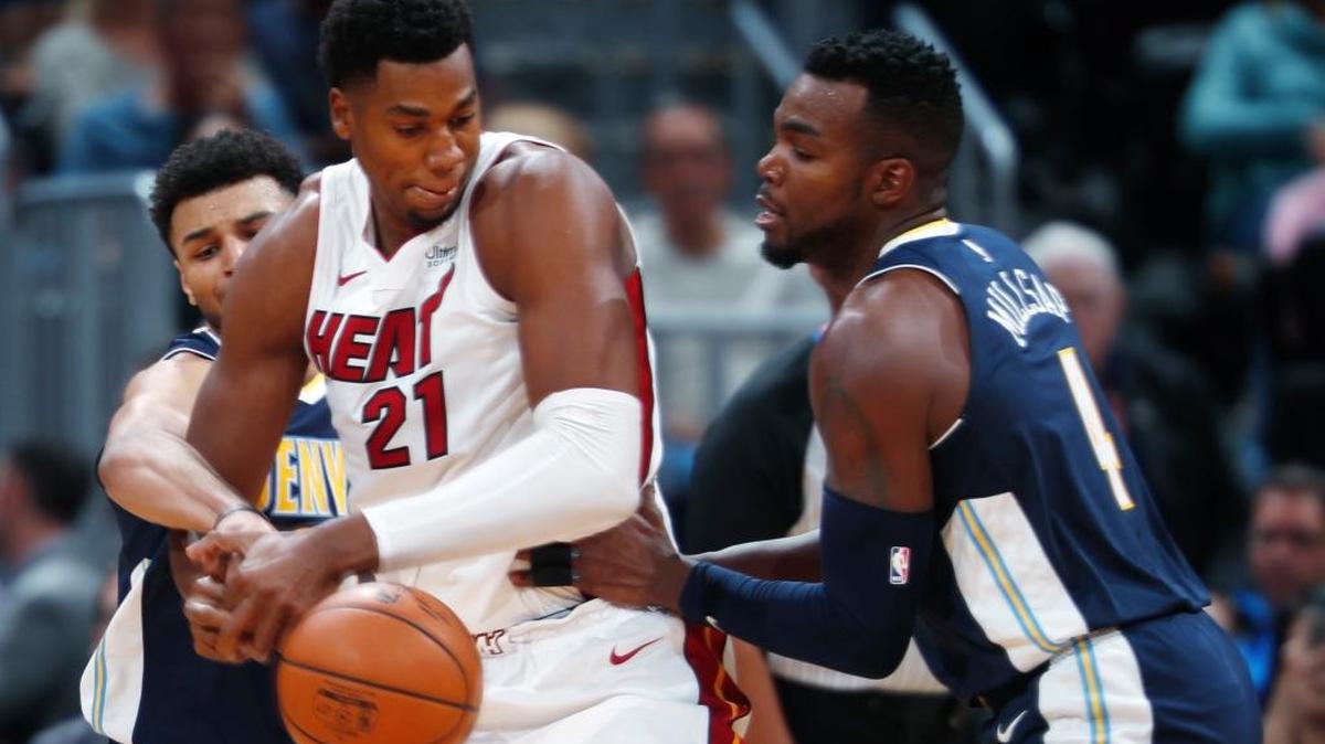 El centro del Heat Hassan Whiteside (#21) pugna con los jugadores de los Nuggets Jamal Murray y Paul Millsap (der.) este viernes 3 en Denver.
