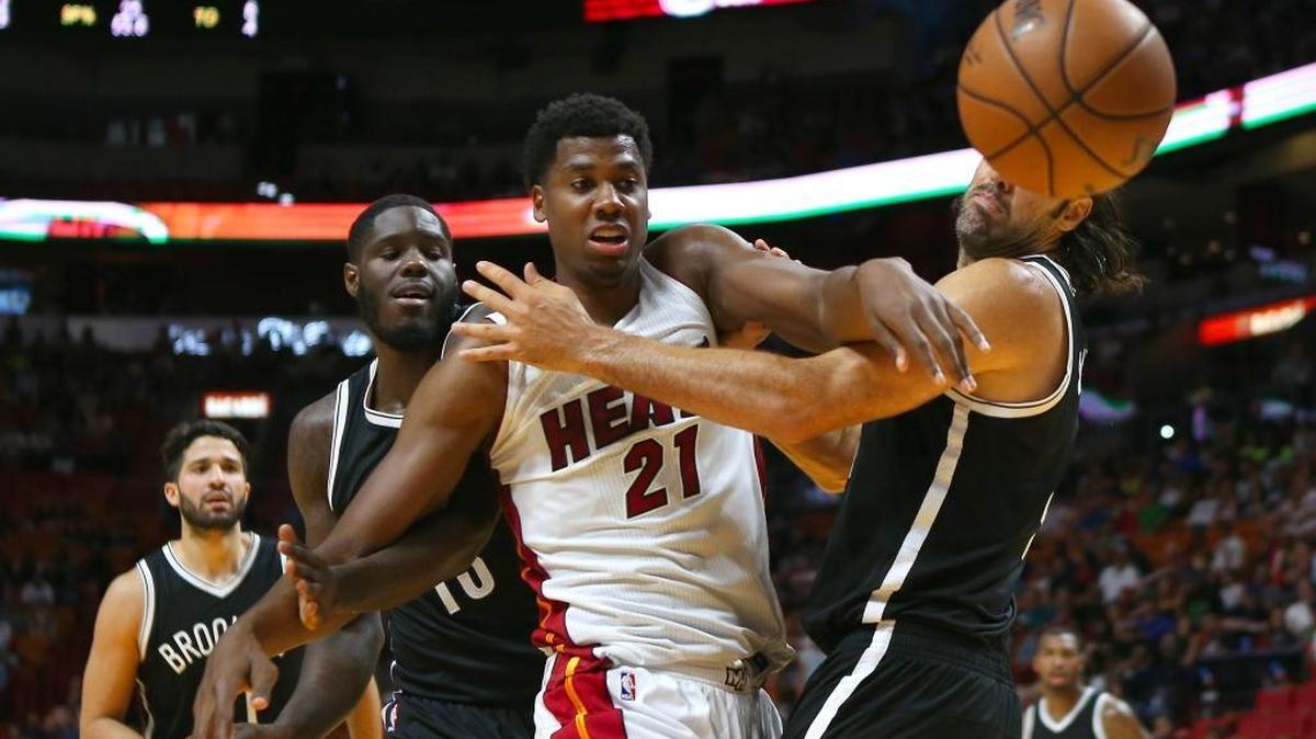 El centro del Heat Hassan Whiteside (#21) lucha por la pelota con los jugadores de los Nets Luis Scola (der.) y Anthony Bennett, en el segundo cuarto del partido de pretemporada, celebrado el 11 de octubre del 2016 en Miami.