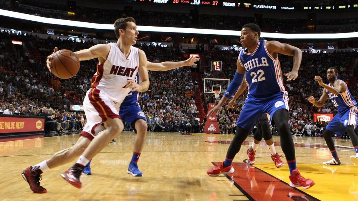 Goran Dragic (izq.) entra al aro por el Heat ante la marca de Richaun Holmes, de Filadelfia, el domingo.