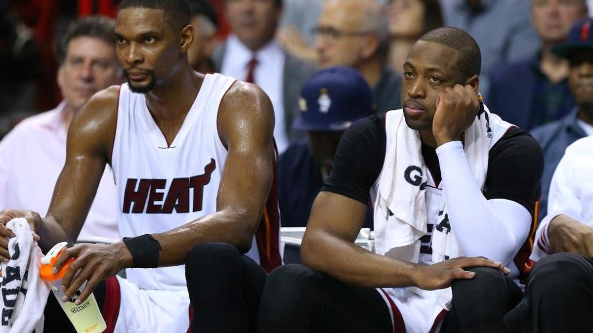 CHRIS BOSH y Dwyane Wade contemplan desde el banco la debacle de su equipo el martes 19 de enero en Milwaukee.