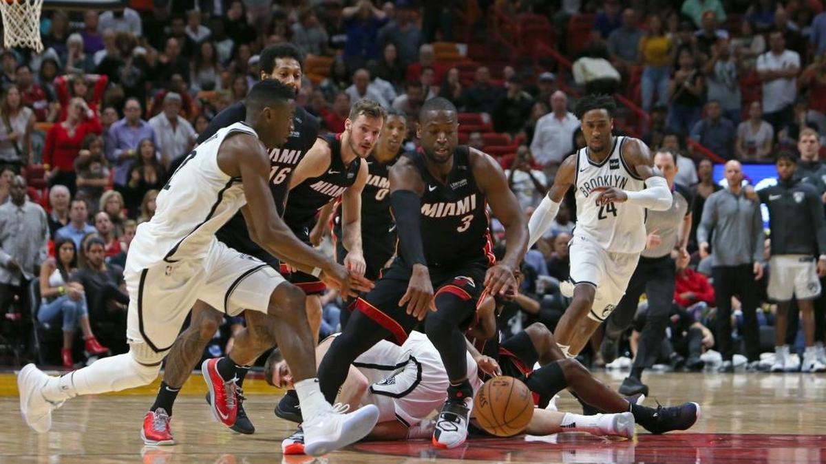 Dwyane Wade, del Heat (3), batalla por un balón suelto contra el jugador de los Nets Caris LeVert (22) este 31 de marzo en el American Airlines Arena.
