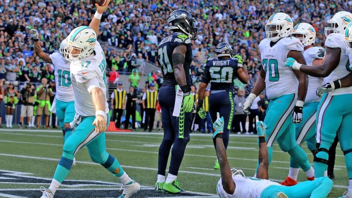 Ryan Tannehill, de los Dolphins, se dispone a enterrar el ovoide tras anotar un touchdown contra los Seahawks, en Seattle, Washington, el domingo 11 de septiembre del 2016.