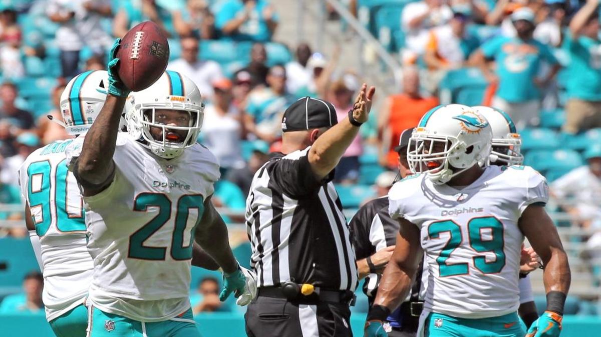 El safety Reshad Jones (20), de los Dolphins, muestra la bola que recuperó para anotar un touchdown contra los Titans en los segundos finales del primer cuarto en el Hard Rock Stadium, el domingo 8 de octubre del 2017. A su lado aparece Nate Allen (29).